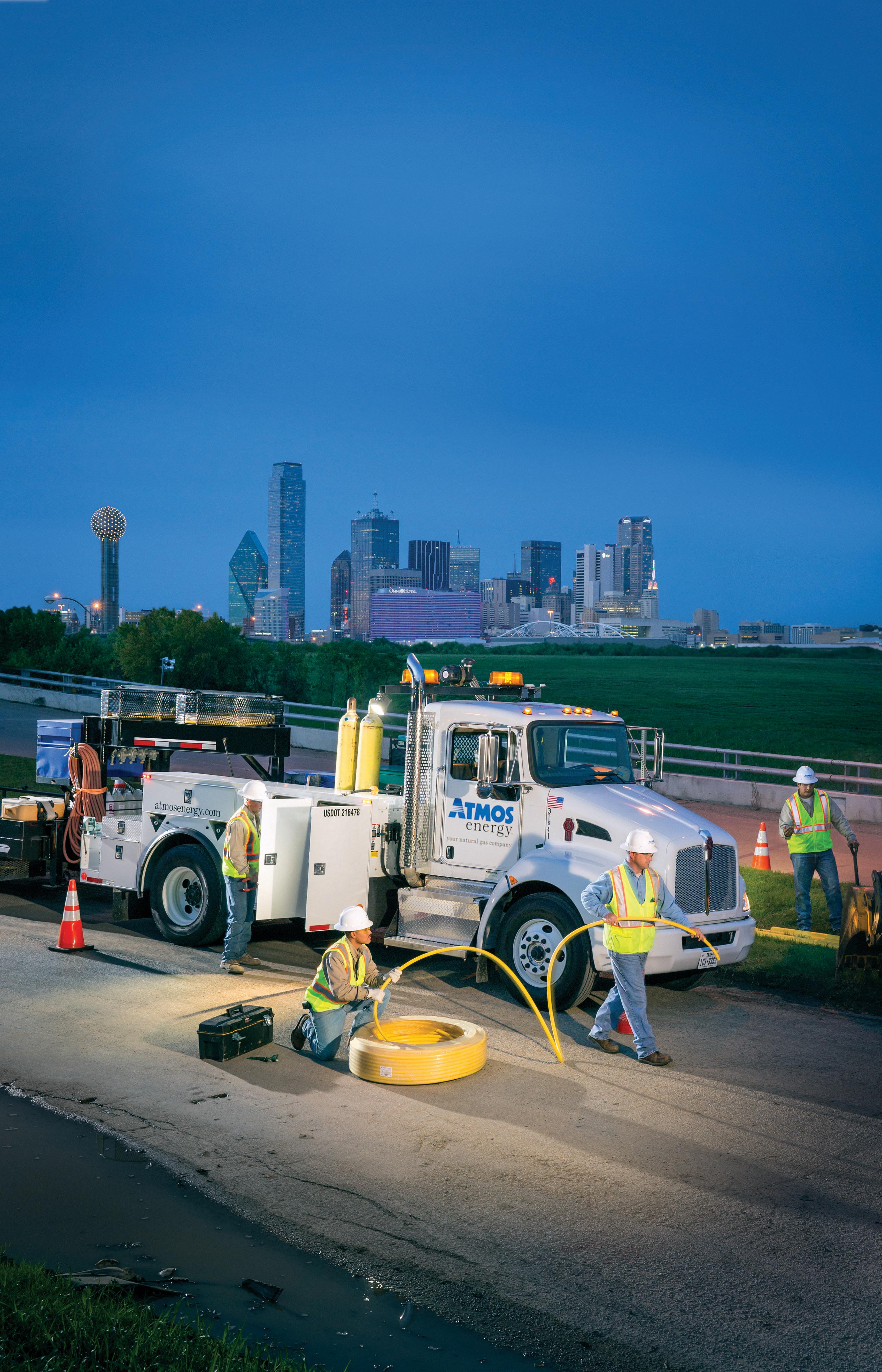 Atmos Energy crew working in the evening in front of downtown Dallas.